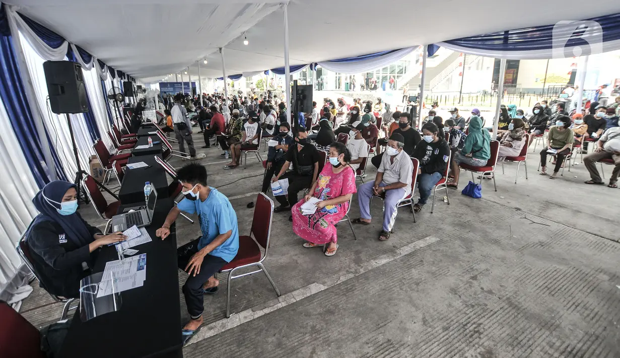 Warga antre mendaftar untuk mengikuti vaksinasi massal Covid-19 di Pasar Ikan Modern Muara Baru, Penjaringan, Jakarta, Kamis (5/8/2021). Vaksinasi massal di Pasar Ikan Muara Baru pada 5-7 Agustus ini menyasar masyarakat kawasan pesisir yang berusia 12 tahun ke atas. (merdeka.com/Iqbal S Nugroho)