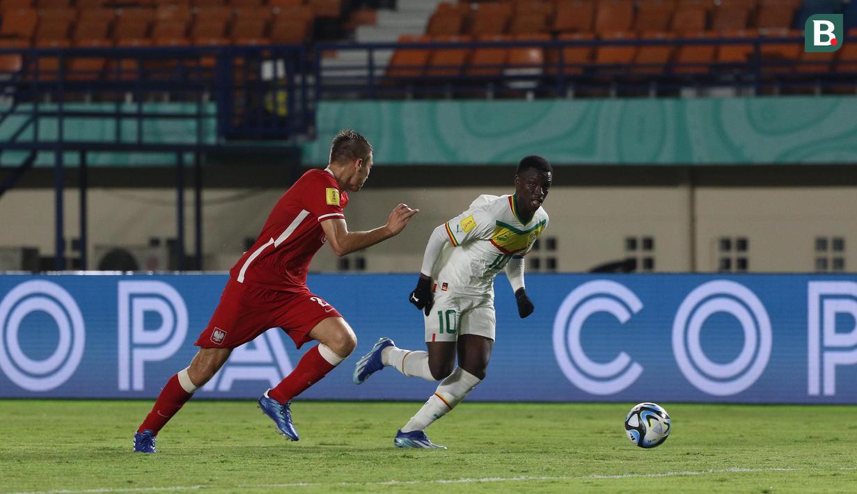 <p>Pemain Timnas Senegal U-17, Amara Diouf (kanan) menguasai bola dibayangi pemain Timnas Polandia U-17, Dominik Szala pada laga kedua Grup D Piala Dunia U-17 2023 di Stadion Si Jalak Harupat, Kabupaten Bandung, Selasa (14/11/2023). (Bola.com/Ikhwan Yanuar)</p>