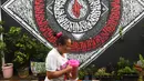 Warga melintas dengan latar belakang warna-warni cat dinding dan grafiti di Kampung Bekelir, Babakan Kota Tangerang, Jumat (16/11). Kampung ini dihuni sekitar 300 KK. (Liputan6.com/Fery Pradolo)
