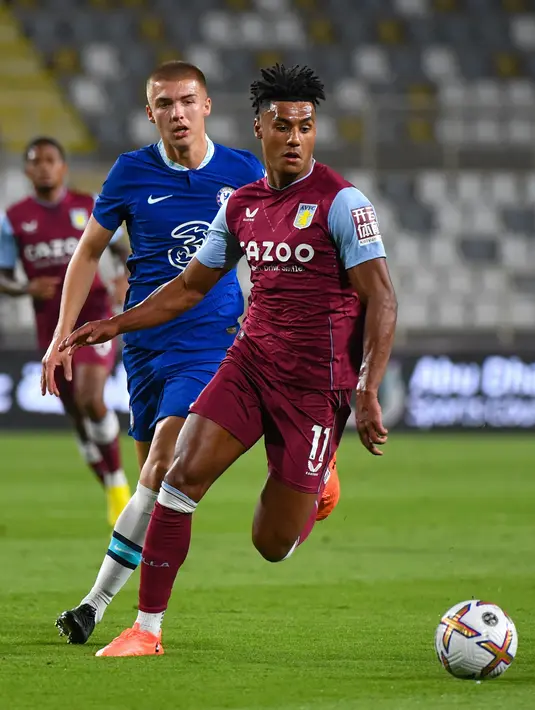 Penyerang Aston Villa, Ollie Watkins membawa bola dari kawalan bek Chelsea, Alfie Gilchrist selama pertandingan uji coba di Stadion al-Nahyan di Abu Dhabi (11/12/2022). Aston Villa menang tipis atas Chelsea dengan skor 1-0. (AFP/Ryan Lim)