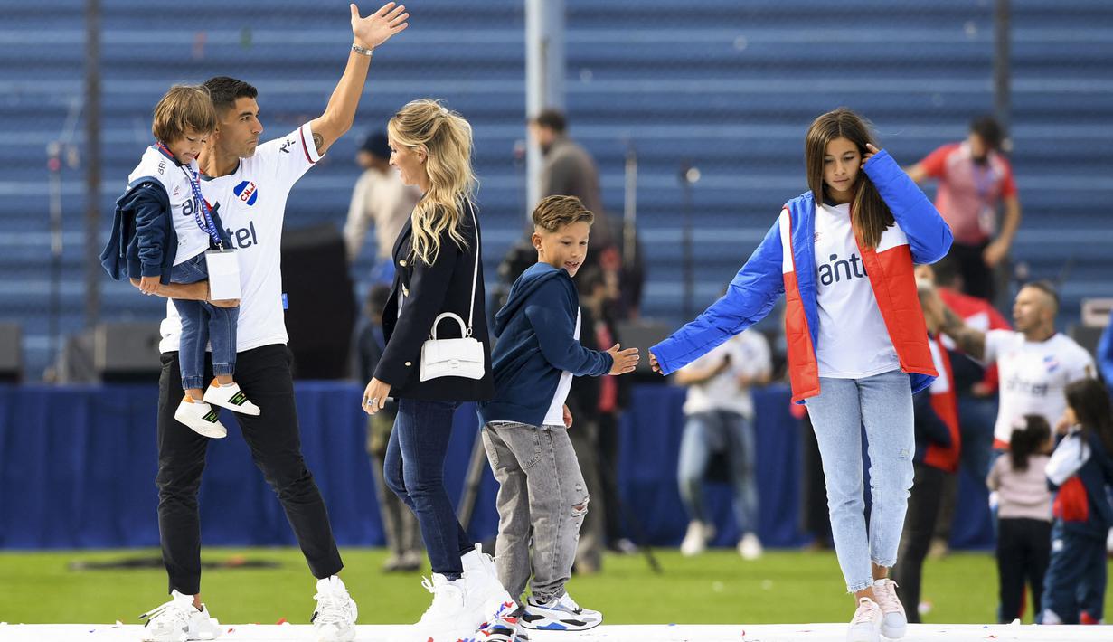 Luis Suarez bersama keluarganya menyapa para fans saat upacara penyambutan sebagai pemain baru Nacional di Stadion Gran Parque Central, di Montevideo, pada 31 Juli, 2022. Luis Suarez kembali ke Uruguay untuk bergabung dengan Nacional, klub tempat ia memulai karirnya 17 tahun lalu sebagai salah satu striker terbaik di generasinya. (AFP/Pablo Porciuncula)