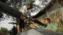 Gambar yang diambil pada 17 November 2019, Jujun Junaedi (kiri) menyelesaikan pembuatan helikopter buatannya di halaman belakang rumahnya di Sukabumi. Jujun merogoh kocek hingga lebih dari RP 30 juta rupiah untuk merakit helikopter bermesin genset dua silinder 700 cc ini. (Wulung WIDARBA/AFP)