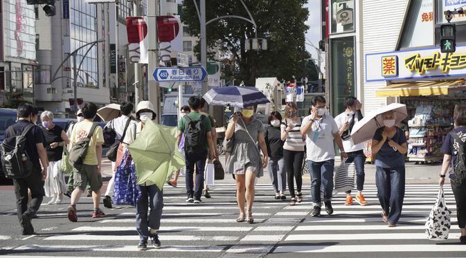 Orang-orang yang memakai masker untuk membantu mengekang penyebaran virus corona COVID-19 berjalan di jalan di Tokyo, Jepang, Jumat (6/8/2021). Tokyo berada dalam keadaan darurat virus corona COVID-19 sejak pertengahan Juli. (AP Photo/Kantaro Komiya)