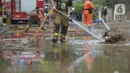 Petugas pemadam kebakaran menyemprotkan air untuk membersihkan lumpur sisa banjir di Kawasan Bukit Duri, Jakarta, Sabtu (4/1/2020). Meski banjir sudah mulai surut, jalan-jalan dan permukiman warga masih tertutup lumpur tebal. (merdeka.com/Imam Buhori)