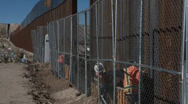 Pekerja menyelesaikan pembangunan tembok yang memisahkan AS dengan Meksiko, Rabu (25/1). Rencananya Trump Wall atau Tembok Trump akan dibangun di perbatasan AS dan Meksiko sepanjang 3.200 kilometer. (AP PHOTO)