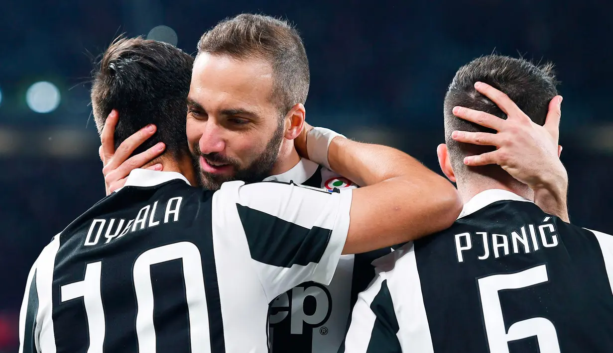 Striker Juventus Gonzalo Higuain (tengah) memeluk dua rekannya saat merayakan gol yang diciptakan Paulo Dybala ke gawang AC Milan pada pertandingan Serie A Italia di Stadion Allianz di Turin (31/3). (Alessandro Di Marco/ANSA via AP)