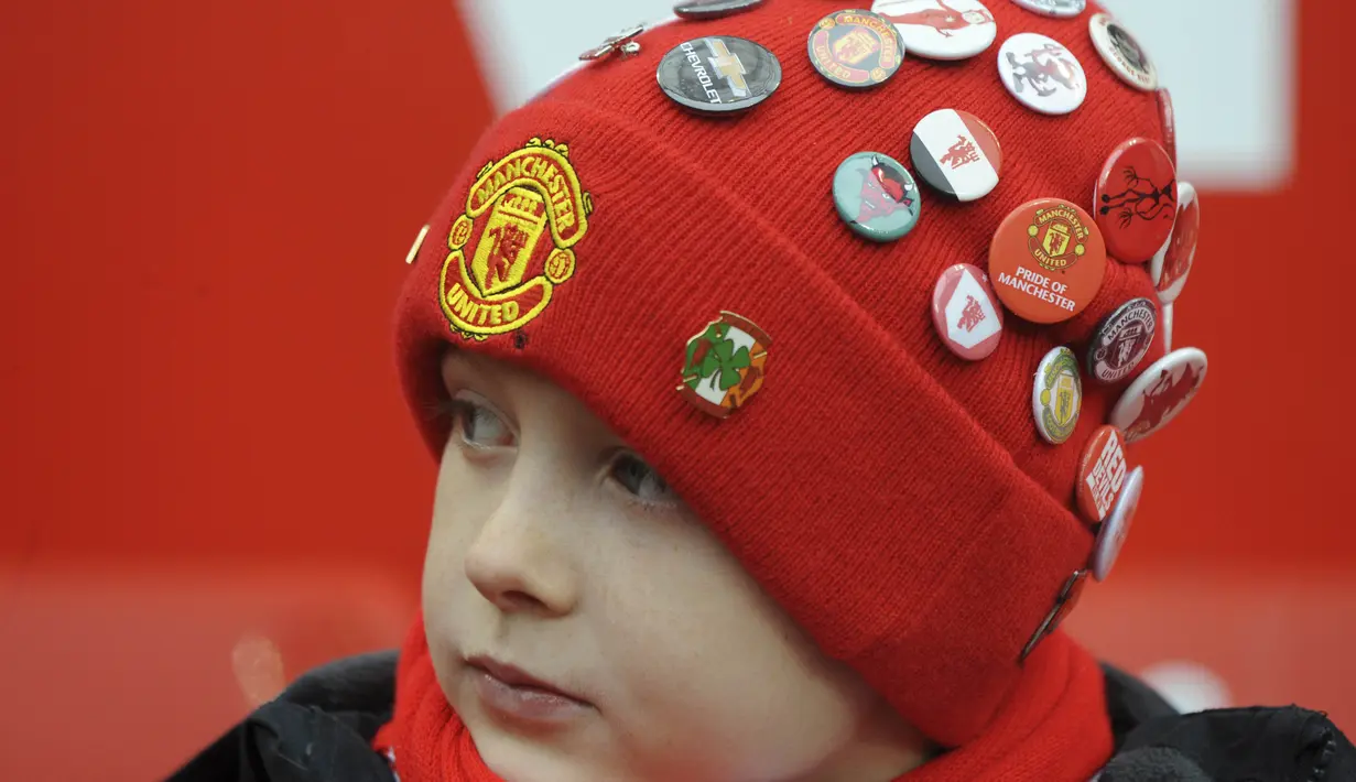 Fans cilik Manchester United dengan topi yang penuh dengan pin tim kesayangannya Setan Merah serius menyaksi laga Piala FA di Old Trafford, (7/1/2017). Setan Merah menang 4-0. (AP/Rui Vieira)