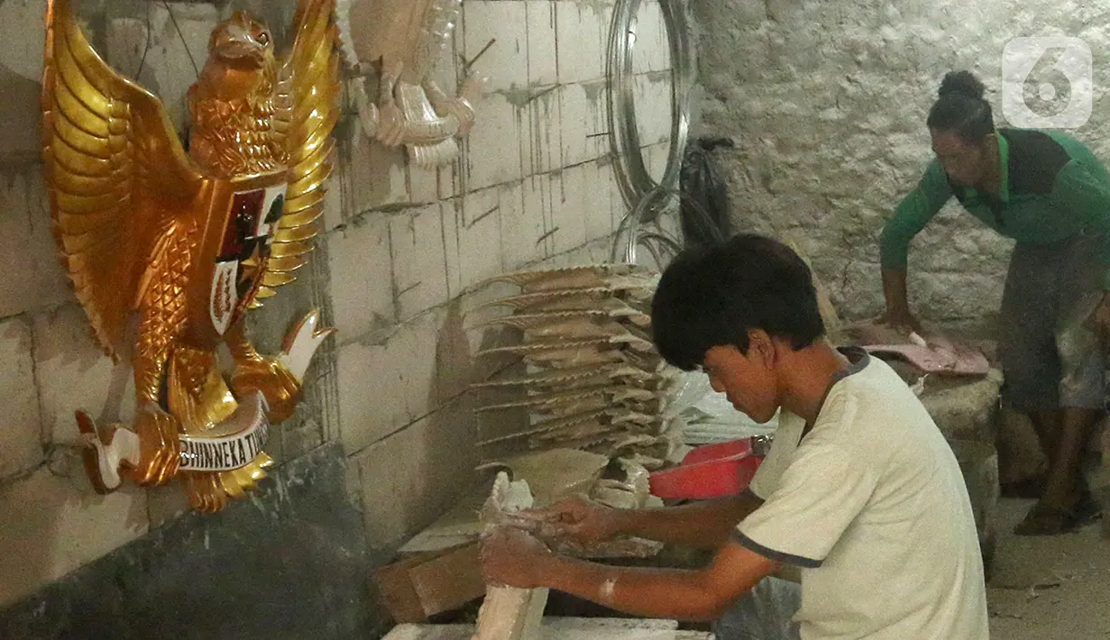 Perajin menyelesaikan pembuatan patung Garuda Pancasila yang terbuat dari serat kaca (fiberglas) di kawasan Kalimalang, Jakarta Timur, Selasa (16/8/2022). Patung Garuda Pancasila dijual dengan harga Rp 300 ribu hingga Rp 3 juta. (merdeka.com/Arie Basuki)