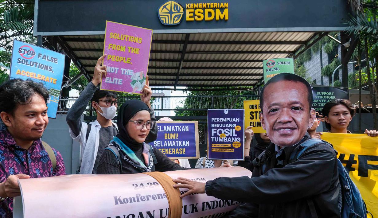 Sebagai informasi, TAFF merupakan konferensi internasional pertama yang khusus membahas perencanaan dan pelaksanaan penghentian ketergantungan global pada bahan bakar fosil secara adil. Tampak dalam foto, seorang aktivis lingkungan (kanan), mengenakan topeng Menteri Energi dan Sumber Daya Mineral, Bahlil Lahadalia, saat unjuk rasa mendesak pemerintah Indonesia untuk menunjukkan komitmen terhadap transisi dari bahan bakar fosil di depan kantor Kementerian Energi dan Sumber Daya Mineral (ESDM), Jakarta, Rabu 22 April 2026. (BAY ISMOYO/AFP)