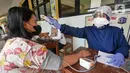 Petugas kesehatan dari Puskesmas Kecamatan Matraman melakukan skrining saat vaksinasi COVID-19 di SD Negeri 25 Utan Kayu Selatan, Matraman, Jakarta Timur, Rabu (23/3/2022). Vaksin yang digunakan adalah vaksin AstraZeneca untuk dosis pertama, kedua dan ketiga (booster). (Liputan6.com/Herman Zakharia)
