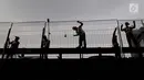 Pekerja mengecat pagar pembatas jalan tol di Tomang, Kebun Jeruk, Jakarta, Rabu (30/5). Selain untuk perawatan, pengecatan tersebut untuk memberikan kenyamanan menyambut Hari Raya Idul Fitri. (Liputan6.com/Johan Tallo)