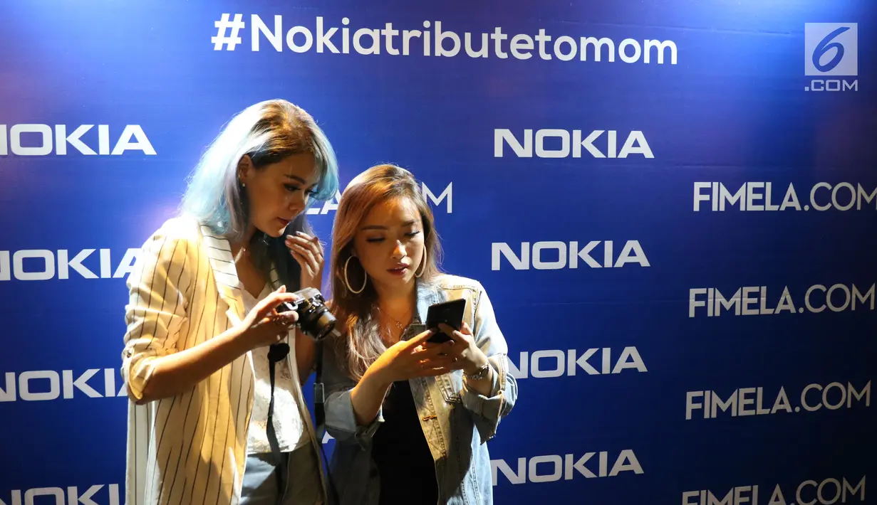 Dua orang selebgram melihat produk Nokia saat acara #Nokiatributetomom yang diselenggarakan Fimela.com dan Nokia di Kota Kasablanka, Jakarta, Minggu (27/5). Pihak Nokia memperkenalkan produk terbarunya. (Liputan6.com/Helmi Fithriansyah)