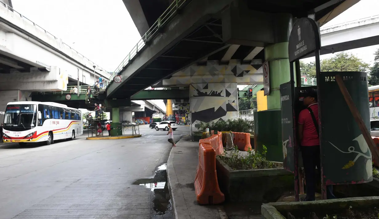 Warga menggunakan toilet umum di sepanjang jalan utama di Manila, Filipina, (24/11). Tidak seperti umumnya, toilet di Filipina ini dibangun di bawah jembatan dan berada di tempat terbuka. (AFP Photo/Ted Aljibe)