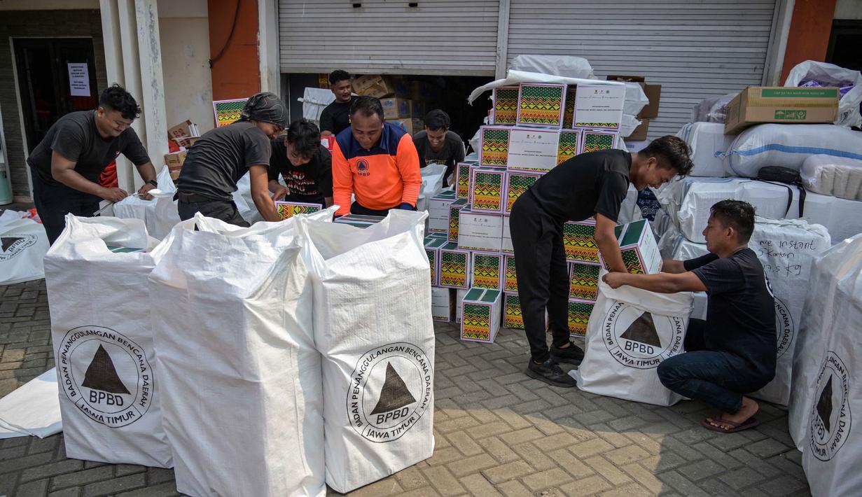 Tak hanya barang, Pemprov Jatim juga menggelontorkan bantuan uang senilai total Rp 10,5 miliar untuk tiga provinsi terdampak bencana, yakni Sumatera Utara, Sumatera Barat, dan Aceh. Tampak dalam foto, para relawan mengemasi perlengkapan untuk dikirimkan ke daerah-daerah terdampak banjir di Badan Penanggulangan Bencana Daerah (BPBD) Sidoarjo, Provinsi Jawa Timur, pada Jumat 5 Desember 2025. (JUNI KRISWANTO/AFP)