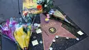 Karangan bunga dan memorabilia menghiasi bintang Walk of Fame milik legenda Marvel, Stan Lee di California, Senin (12/11). Stan Lee, kreator Captain America dan beberapa tokoh superhero Marvel lainnya, meninggal dunia di usia 95 tahun. (AP/Reed Saxon)