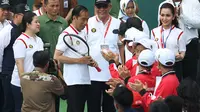Presiden Joko Widodo (Jokowi) secara simbolis menerima raket tenis dari petenis legendaris Indonesia, Yayuk Basuki saat peresmian lapangan tenis indoor dan outdoor Senayan di Jakarta, Sabtu (3/2). (Liputan6.com/Angga Yuniar)