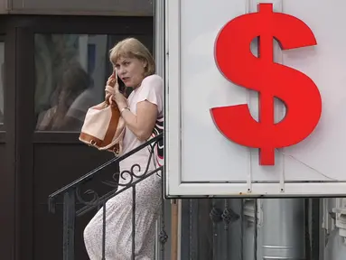 Seorang wanita meninggalkan kantor penukaran mata uang di St. Petersburg, Rusia, Kamis (6/7/2023). Presiden Rusia Vladimir Putin mengatakan ekonomi Rusia berkinerja lebih baik dari yang diperkirakan. (AP Photo/Dmitri Lovetsky)