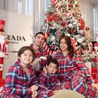 Jessica Iskandar kompak mengenakan piyama kotak-kotak warna merah dengan suami dan ketiga anak-anaknya. Keluarga ini pun berfoto di depan pohon natalnya tahun ini. [@inijedar]