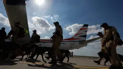 Anggota tim SAR Ceko beserta anjing pelacak berjalan menaiki pesawat di bandara Vaclav Havel di Praha, Rabu (5/8/2020). Republik Ceko mengirimkan sekitar 37 personel dan lima ekor anjing pelacak untuk membantu pencarian korban ledakan dahsyat di Beirut, Lebanon. (AP Photo/Petr David Josek)