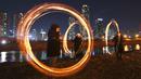 Peserta memutar kaleng arang yang terbakar menjelang perayaan "Jeongwol Daeboreum" (Bulan Purnama) di sebuah taman di Seoul, Korea Selatan (1/3). Permainan ini dipercaya dapat menyuburkan tanah dan menyingkirkannya hama. (AFP Photo/Jung Yeon-je)