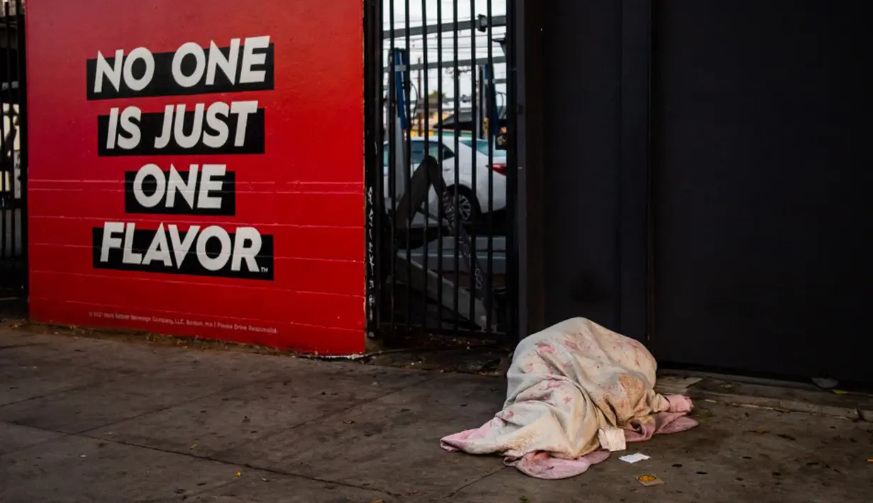 Seorang tunawisma tidur di trotoar di Venesia, California, Amerika Serikat, 12 Agustus 2021. (Apu GOMES/AFP)