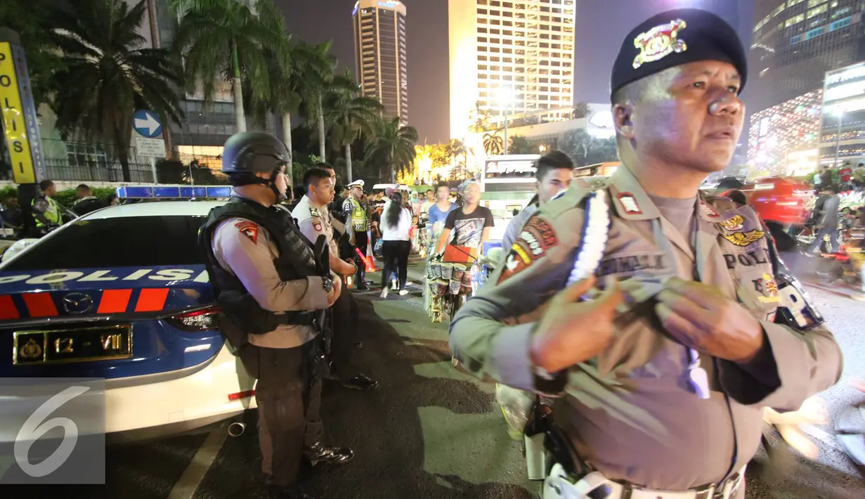 Petugas kepolisian bersenjata lengkap berjaga di kawasan Bundaran HI, Jakarta, Sabtu (31/12). Untuk mengamankan jalannya perayaan malam tahun baru, Polda Metro Jaya menempatkan personelnya di sejumlah sudut Ibu Kota. (Liputan6.com/Immanuel Antonius)