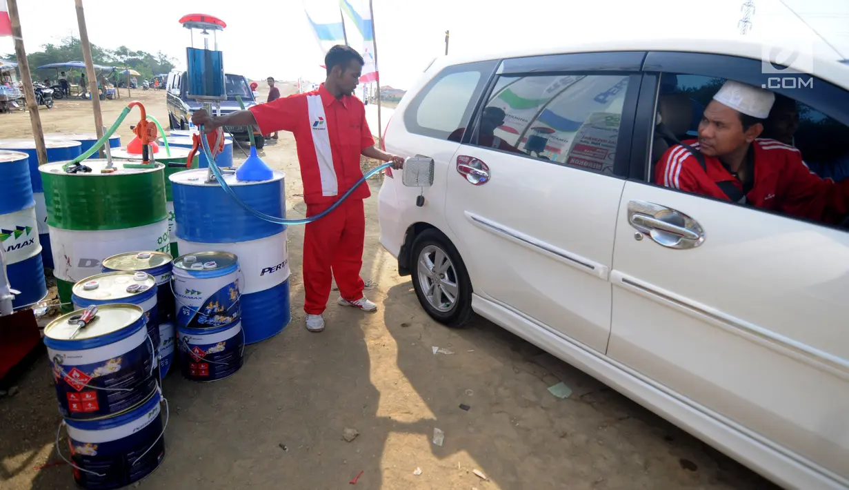 Petugas mengisi bahan bakar minyak (BBM) ke sebuah mobil pemudik di kios Pertamina jalan tol fungsional Brebes Timur - Pemalang Km 275, Kabupaten Tegal, Jawa Tengah, Rabu (21/6). (Liputan6.com/Gempur M Surya)