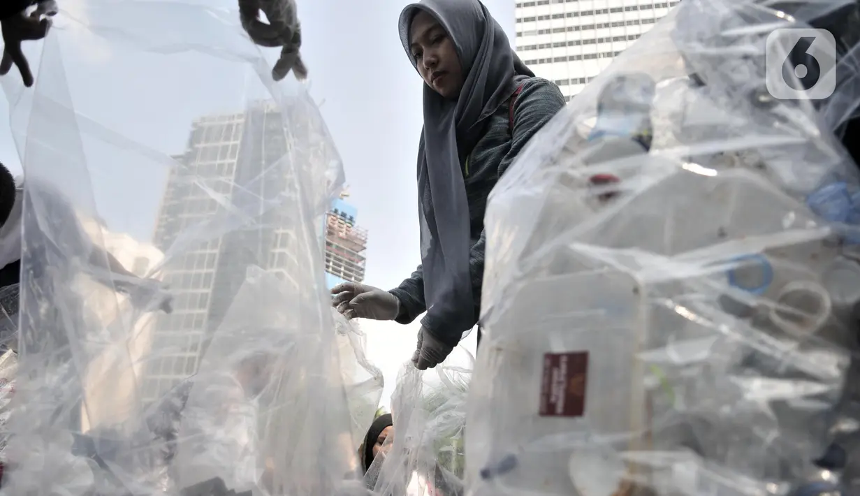 Aktivis yang tergabung dalam Sekolah Relawan memunguti sampah saat aksi Jakarta Clean Action selama Hari Bebas Kendaraan Bermotor (HBKB) di kawasan Bundaran HI, Jakarta, Minggu (1/12/2019). (merdeka.com/Iqbal S. Nugroho)