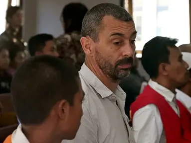 Warga negara Prancis, Samuel Pierre Danguny (kedua kiri) menunggu untuk menjalani sidang di Pengadilan Negeri Denpasar, Bali, Kamis (1/8/2019). Pierre diamankan pada 15 Maret 2019 dengan barang bukti berupa 6 paket ganja, 2 paket hasis, dan 1 paket sabu.  (SONNY TUMBELAKA/AFP)