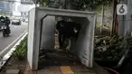Pejalan kaki melintas di antara beton saluaran air yang berada di jalur pedestrian kawasan Gatot Subroto, Jakarta, Selasa (21/12/2021). Selain mengganggu kenyamanan, keberadaan beton saluran air tersebut juga dapat membahayakan pejalan kaki yang melintas. (Liputan6.com/Faizal Fanani)