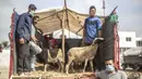 Pedagang mengenakan masker saat menunggu pelanggan membeli domba untuk perayaan Idul Adha di sebuah pasar di pinggiran Rabat, Maroko, Kamis (30/7/2020). (AP Photo/Mosaab Elshamy)