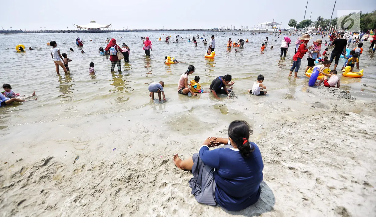 Pengunjung memadati Pantai Lagoon di Ancol, Jakarta Utara, Jumat (17/8). Warga Jakarta dan sekitarnya memanfaatkan libur HUT ke-73 Republik Indonesia dengan berwisata ke kawasan Ancol. (Liputan6.com/Faizal Fanani)
