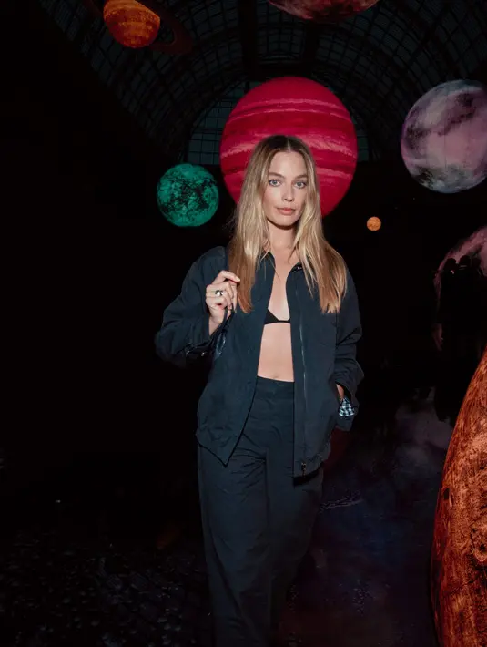 Margot Robbie tampil bak Barbie edgy dengan bra hitam yang dilapisi setelan jaket navy. Celana panjang yang senada dilengkapi dengan shoulder bag hitam [Chanel]