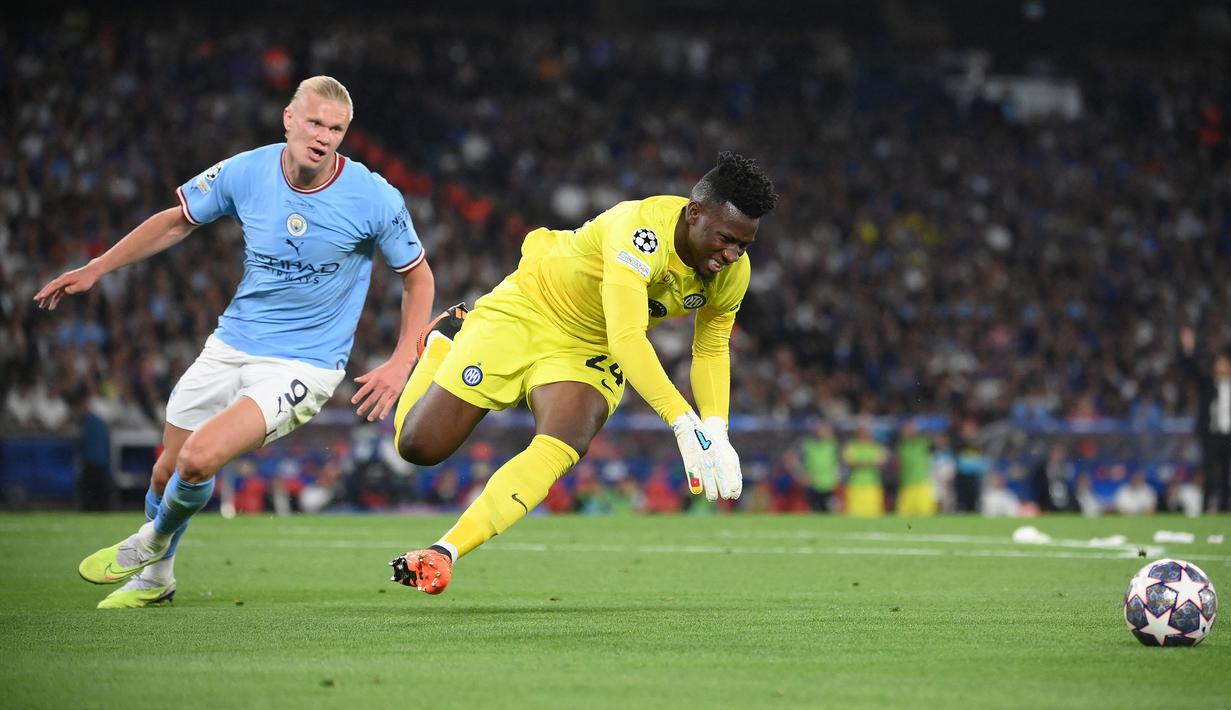 Kiper Inter Milan, Andre Onana (kanan) berebut bola dengan pemain Manchester City, Erling Haaland pada laga final Liga Champions 2022/2023 di Ataturk Olympic Stadium, Istanbul, 10 Juni 2023. (AFP/Franck Fife)