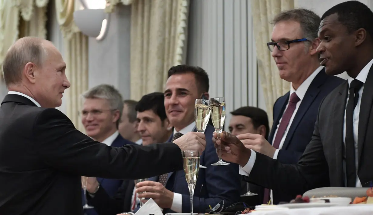 Presiden Rusia Vladimir Putin (kiri) bersulang dengan para legenda sepak bola saat menghadiri undian Piala Dunia 2018 di Moskow, Rusia (1/12). (AFP Photo/Sputnik/Alexey Nikolsky)