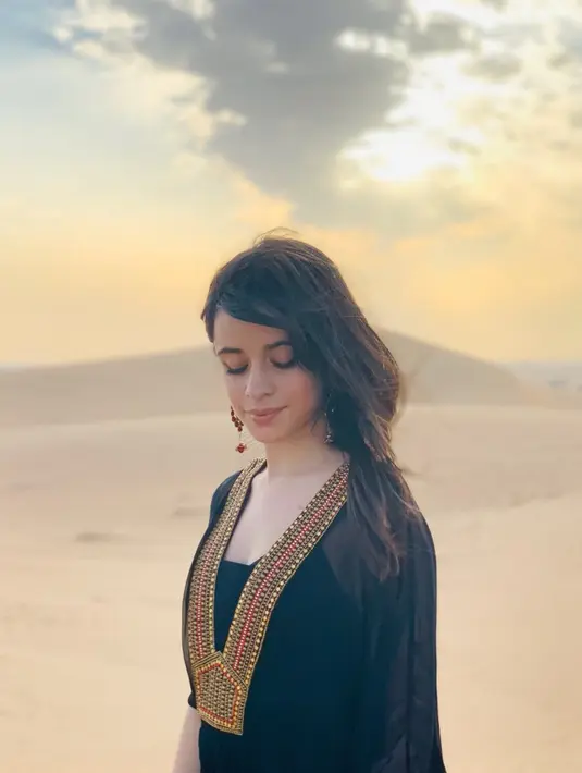 Masih berada di salah satu padang pasir di negeri Arab, Camila berpenampilan layaknya Princess Jasmine di film Aladdin. Dengan rambut hitam yang tergerai ke samping kiri bahunya, Camila tampak sangat cantik dengan latar belakang sinar matahri tertutup awan. (Liputan6.com/IG/@camila_cabello)