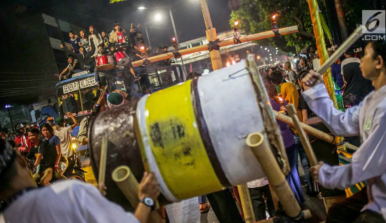Warga konvoi menggunakan bus saat merayakan malam takbiran menyambut Hari Raya Idul Fitri 2019 di kawasan Tanah Abang, Jakarta, Selasa (4/6/2019). Pemerintah menetapkan Hari Raya Idul Fitri 1440 Hijriah jatuh pada hari Rabu 5 Juni 2019. (Liputan6.com/Faizal Fanani)