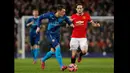 Gelandang Arsenal, Mesut Ozil membawa bola melewati pemain Manchester United Daley Blind saat laga perempat final Piala FA di Stadion Old Trafford, Inggris (10/3/2015). Arsenal Menang 2-1 atas Manchester United.(Reuters/Jason Cairnduff )