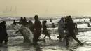 Para pemuda bermain air saat mendinginkan tubuhnya di laut selama musim panas di Karachi, Pakistan (14/6/2019). Memasuki musim panas, warga Pakistan ramai-ramai mendinginkan tubuhnya di laut. (AFP Photo/Asif Hassan)