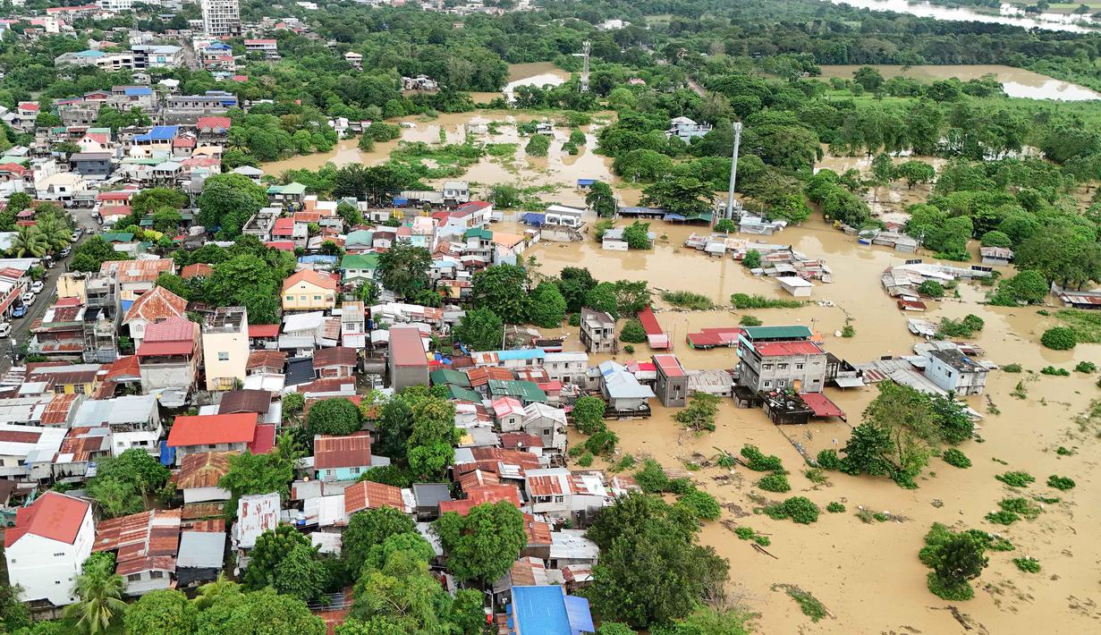 Topan Fung-wong mulai melemah dan meninggalkan Filipina di atas Laut Cina Selatan pada Senin 10 November 2025 pagi hari waktu setempat. Tampak foto udara menunjukkan pemandangan rumah-rumah yang terendam banjir di Kota Tuguegarao, Provinsi Cagayan, di utara Manila pada 10 November 2025, setelah sungai meluap akibat hujan deras yang disebabkan oleh Topan Super Fung-wong. (John DIMAIN/AFP)
