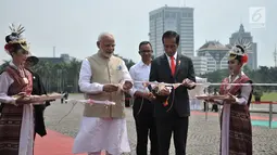 Presiden Joko Widodo (Jokowi) dan PM India Narendra Modi memotong pita saat meresmikan pameran Indonesia-India Kite  Exhibition di kawasan Monas, Jakarta, Rabu (30/5). Pada pameran tersebut, dipamerkan puluhan layang-layang. (Merdeka.com/Iqbal S. Nugroho)
