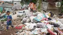 Anak-anak melintasi tumpukan sampah di sekitar Jalan Masjid Al Makmur, Pejaten Timur, Pasar Minggu, Jakarta Selatan, Selasa (10/12/2019). Tumpukan sampah yang tidak hanya berasal dari warga sekitar menimbulkan bau tidak sedap dan dikhawatirkan dapat mengganggu kesehatan. (Liputan6.com/Immanuel Anton