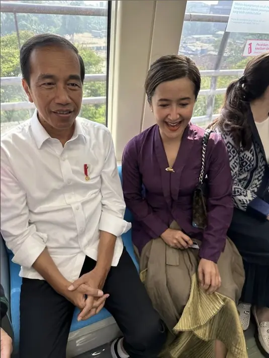 Widi Mulia tampil mengenakan kebaya ungu dipadukan kain warna coklat duduk di sebelah Jokowi. [Instagram/@widimulia]