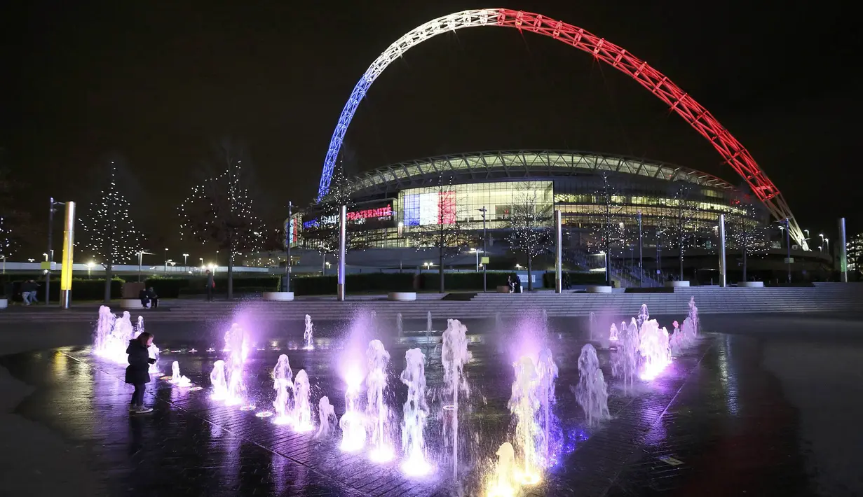 Sebagai bentuk tanda belasungkawa, jelang laga persahabatan Inggris melawan Prancis, Stadion Wembley dihiasi lampu berwarna bendera Prancis, Senin (16/11/2015). (Reuters/Paul Hackett)