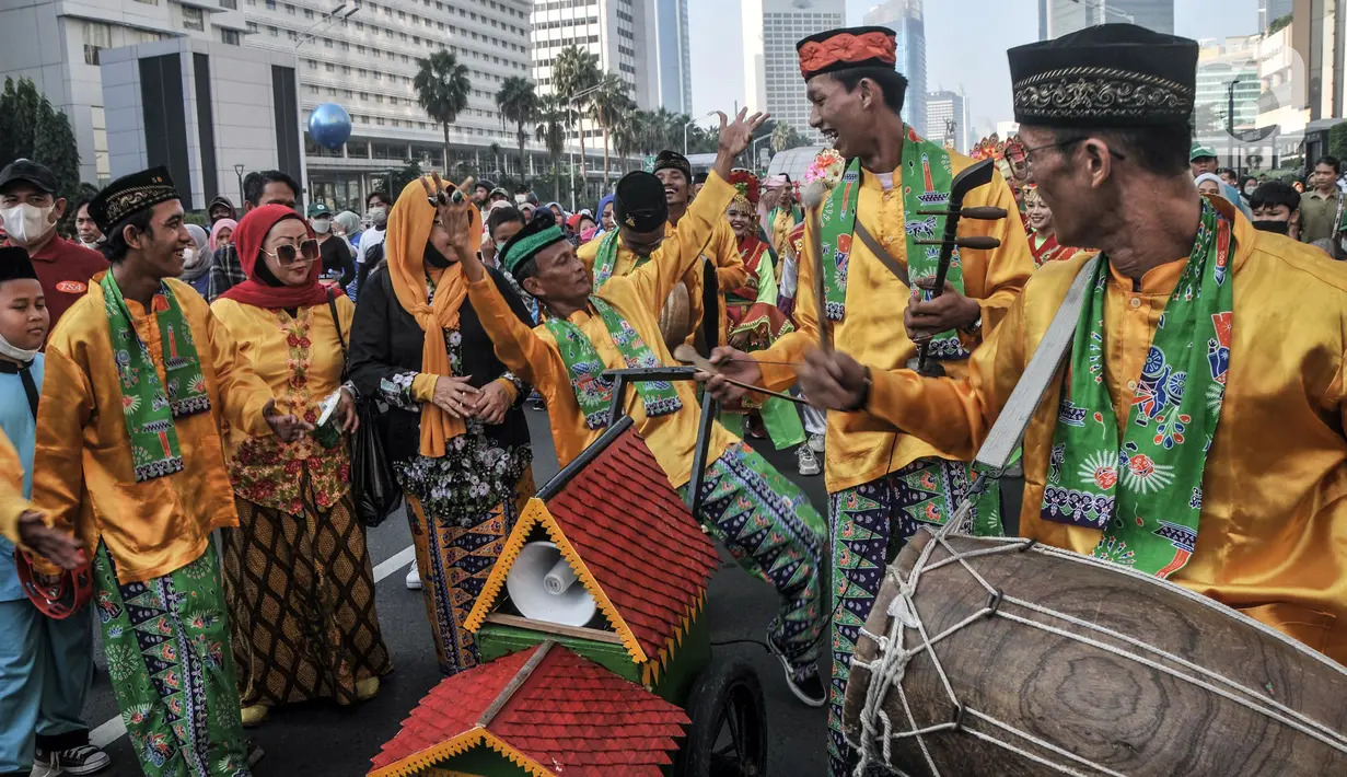 Kesenian Betawi tampil dalam pawai kesenian saat Hari Bebas Kendaraan Bermotor (HBKB) atau car free day (CFD) di Jalan MH Thamrin, Jakarta, Minggu (19/6/2022). Pawai yang menampilkan berbagai budaya dan kesenian Betawi seperti ondel-ondel, tari topeng, serta tanjidor tersebut digelar dalam rangka menyambut HUT ke-495 DKI Jakarta. (merdeka.com/Iqbal S. Nugroho)