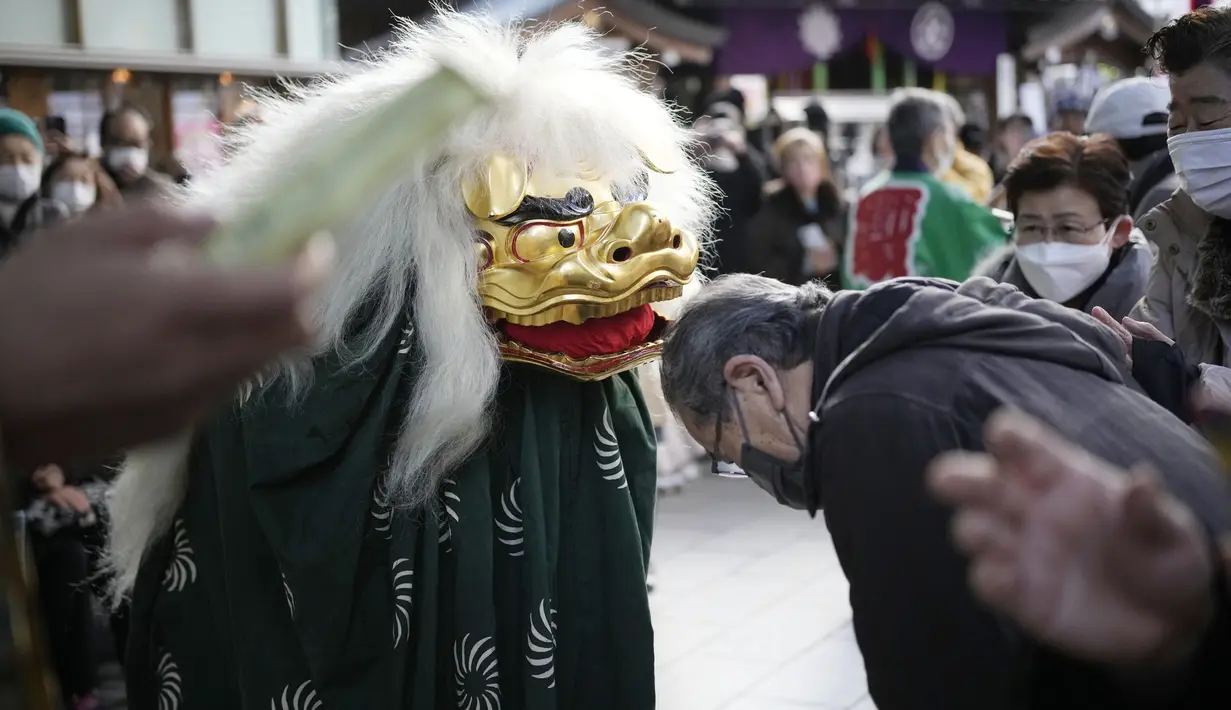 <p>Seorang penari singa, yang dikenal sebagai Shishimai, melakukan tarian ritual selama Festival Konpira di kuil Kotohiragu di distrik bisnis Toranomon, Tokyo, Selasa (10/1/2023). Kehadiran para seniman dalam Festival Konpira pertama di tahun 2023 itu sukses menarik perhatian masyarakat. (AP Photo/Eugene Hoshiko)</p>