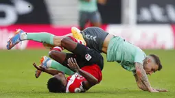 Pemain Everton, Lucas Digne, terjatuh saat berebut bola dengan pemain Southampton, Kyle Walker-Peters, pada laga Liga Inggris di Stadion St. Mary's Minggu (25/10/2020). Southampton menang dengan skor 2-0. (AP Photo/Frank Augstein, Pool)