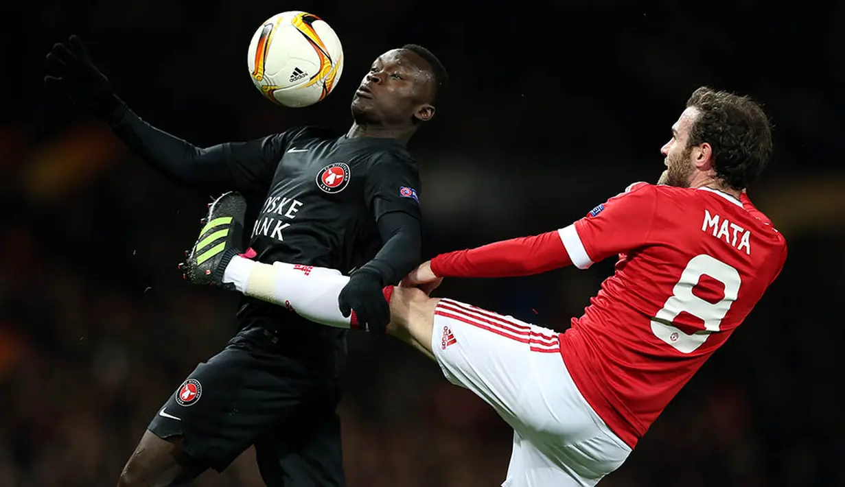 Pemain Midtjylland, Pione Sisto, berebut bola dengan gelandang Manchester United, Juan Mata. Meski pada leg pertama MU takluk 1-2, namun berhasil lolos karena menang 5-1 di kandang. (EPA/Nigel Roddis)