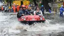  Warga dan pelajar dibantu mobil amfibi melewati genangan air di depan kampus UKRIDA, Jakarta, Selasa (21/1). Hujan deras sejak malam tadi, membuat sejumlah wilayah Jakarta tergenang air banjir. (Liputan6.com/Gempur M Surya)
