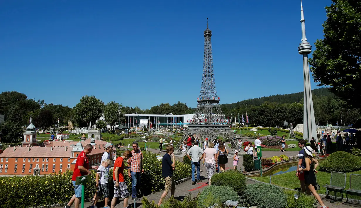 Pengunjung melintas di dekat miniatur Warsawa Royal Palace, Menara Eiffel dan Toronto CN Tower di Taman Minimundus, Klagenfurt, Austria, Senin (8/8). Taman Minimundus menampilkan aneka bangunan unik dari berbagai negara. (REUTERS/Heinz-Peter Bader)